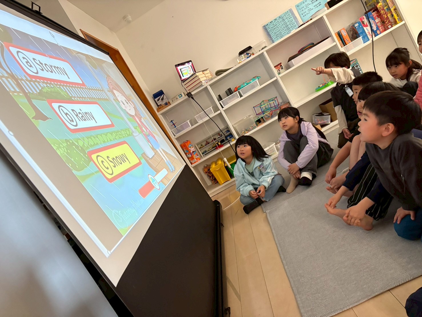 画面を見ながら、英語の学習に参加する子どもたち