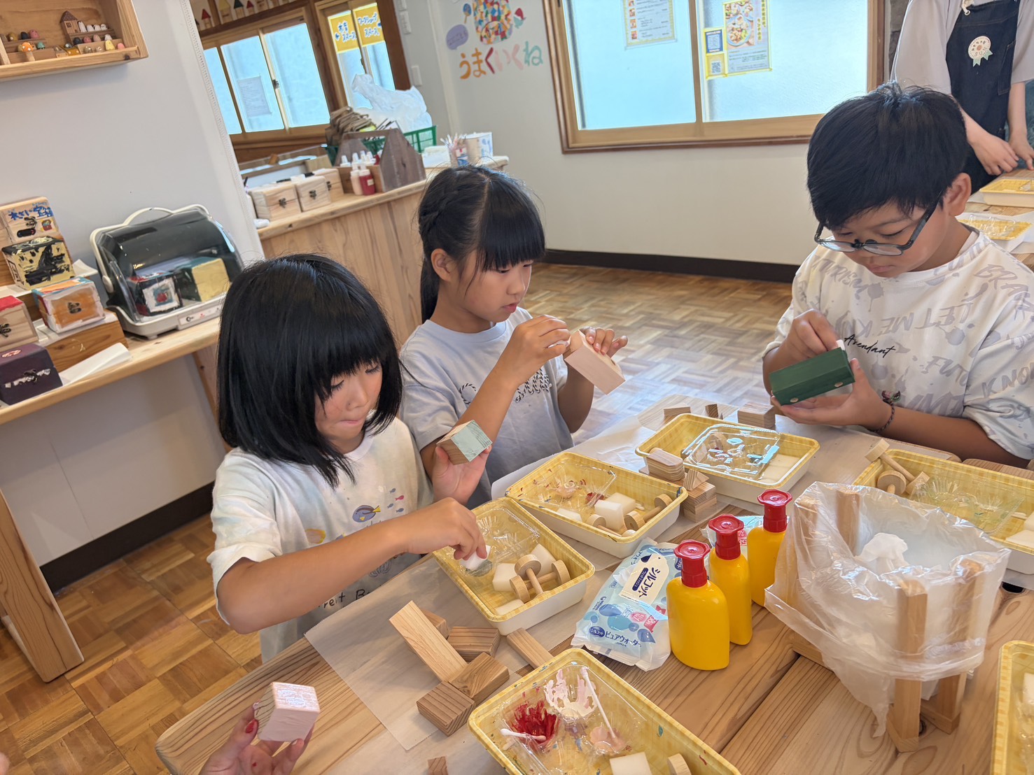 木材を組み合わせて、自分の作品をつくる子どもたち