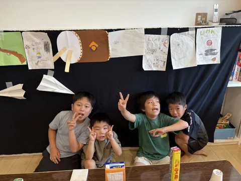 手作りの展示の前で、笑顔やポーズを見せるLinkの子どもたち
