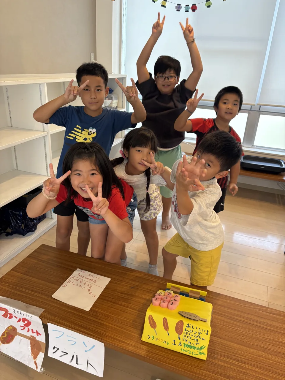 手作りの看板を並べたマルシェの売り場で、笑顔を見せる子どもたち
